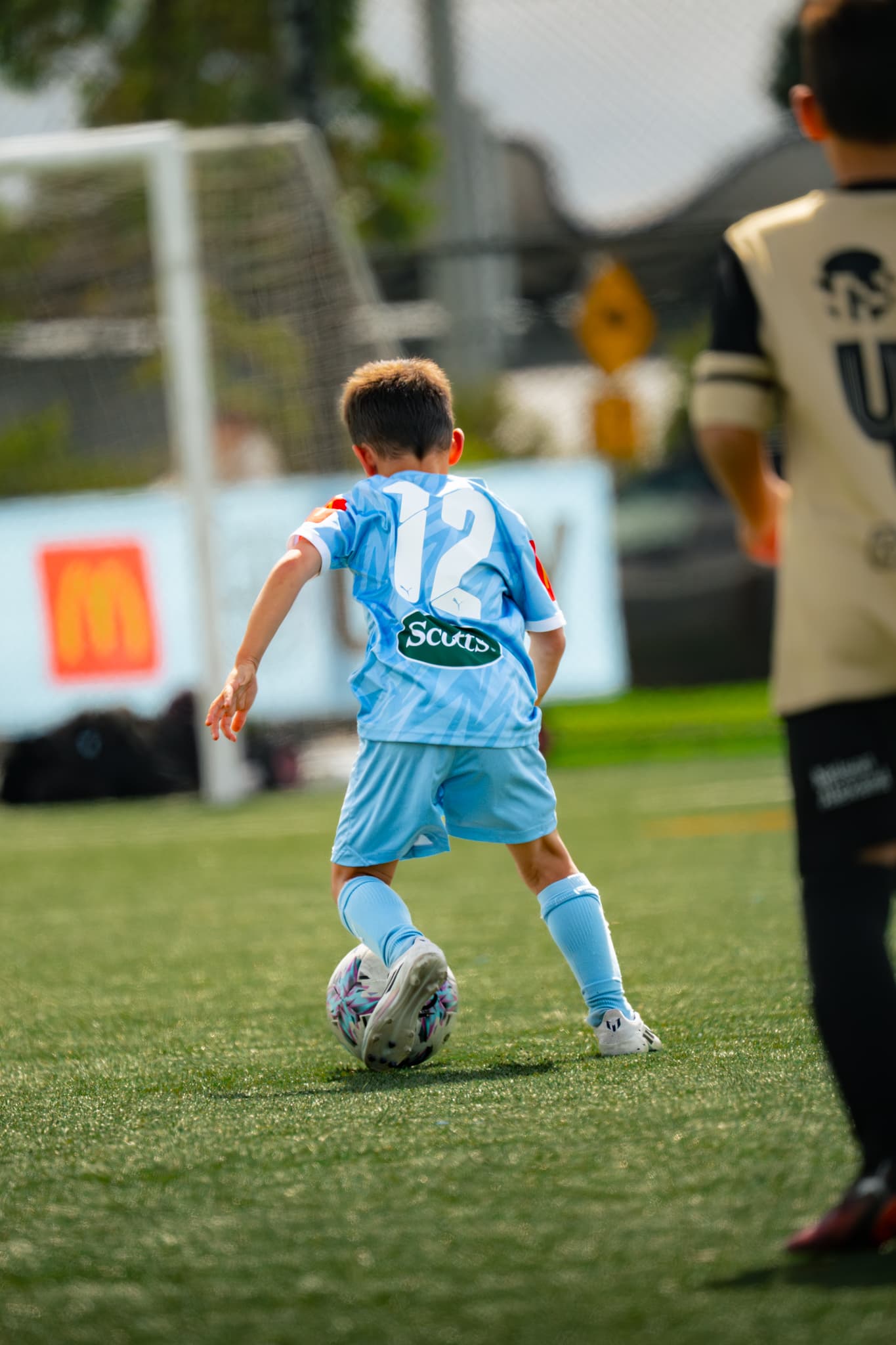 Young football player training on the pitch.